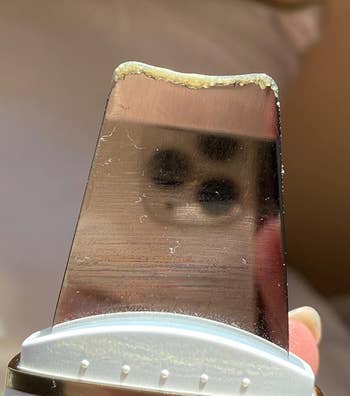 Close-up of the scraper showing dead skin and sebum