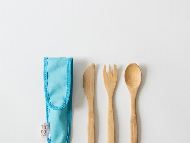 blue carrying case next to a knife, fork, and spoon made of bamboo