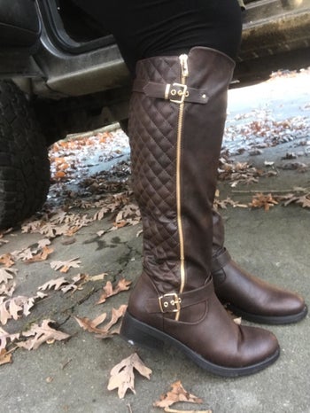 reviewer wears brown knee-high quilted riding boots and black leggings