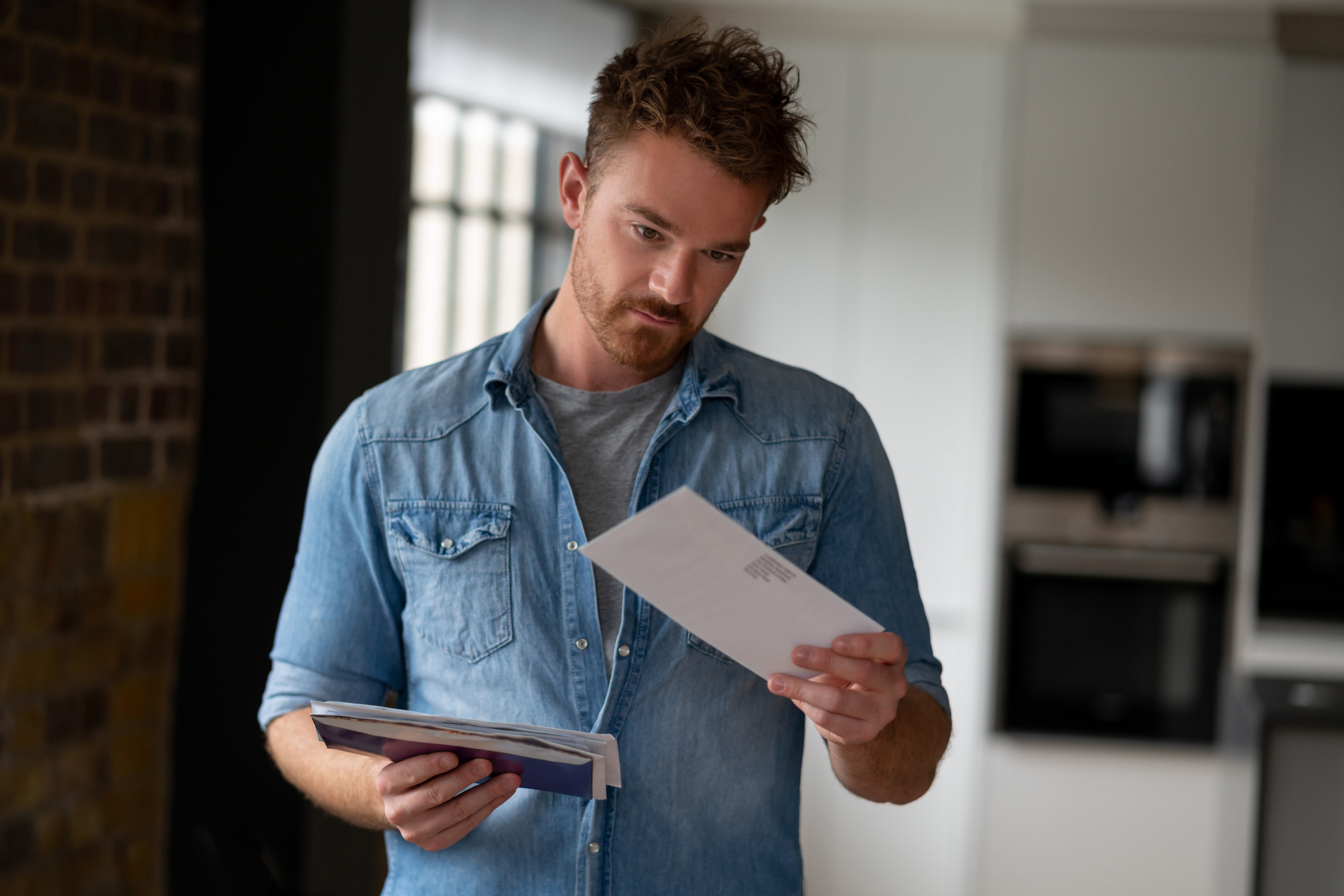 Man looking at bills in the mail