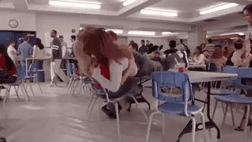 two women fighting and falling over a table