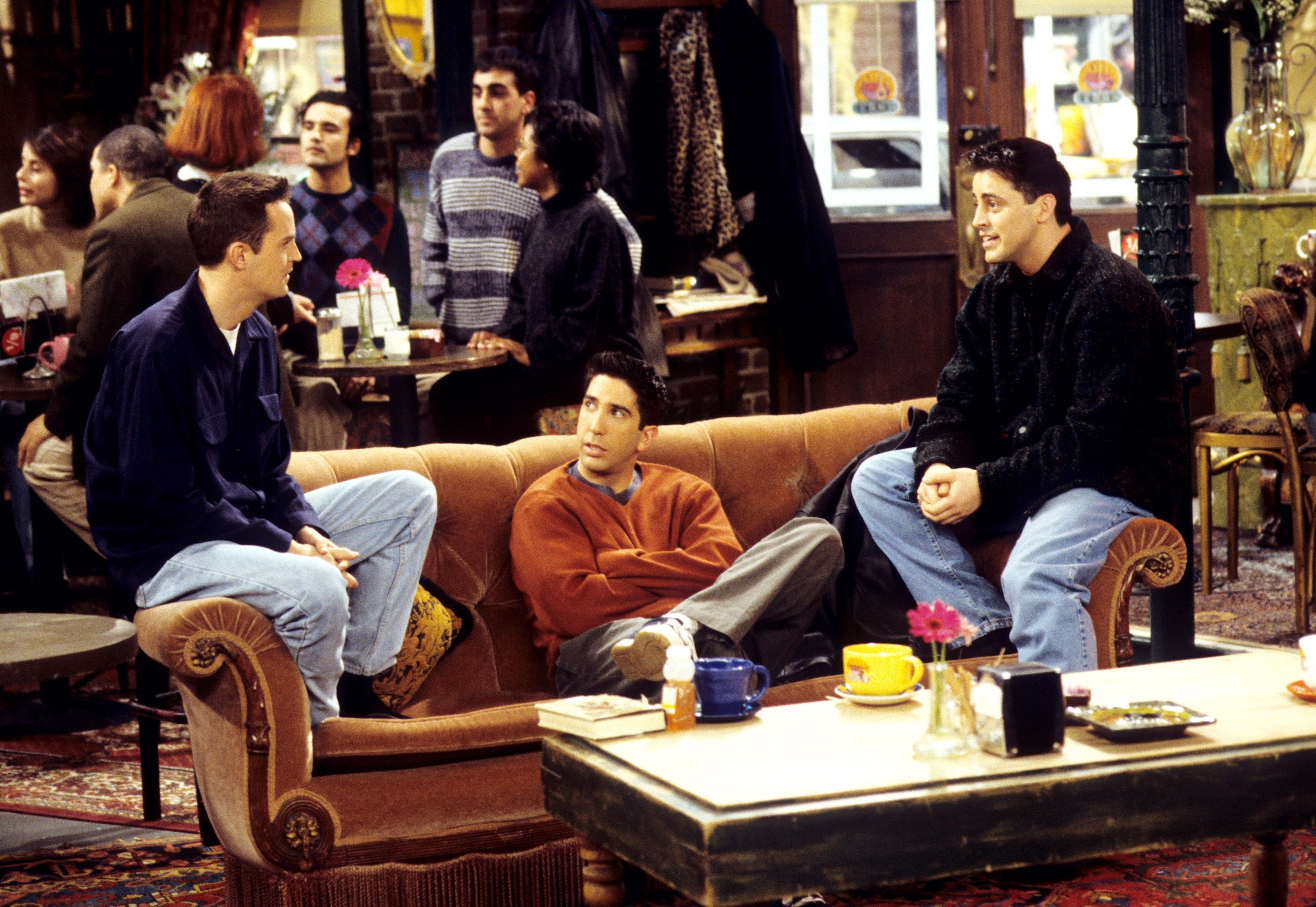 Matthew Perry, David Schwimmer, and Matt LeBlanc sitting on the couch at the Central Perk.