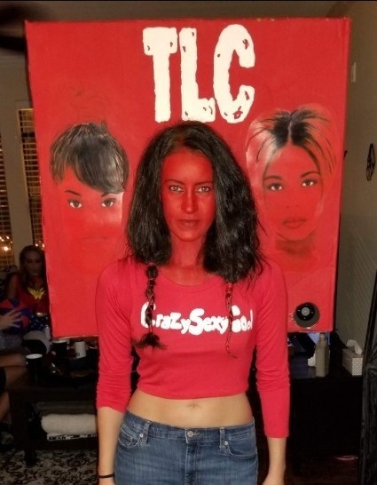 Someone dressed in red with their face cut into the backdrop of the &quot;CrazySexyCool&quot; album