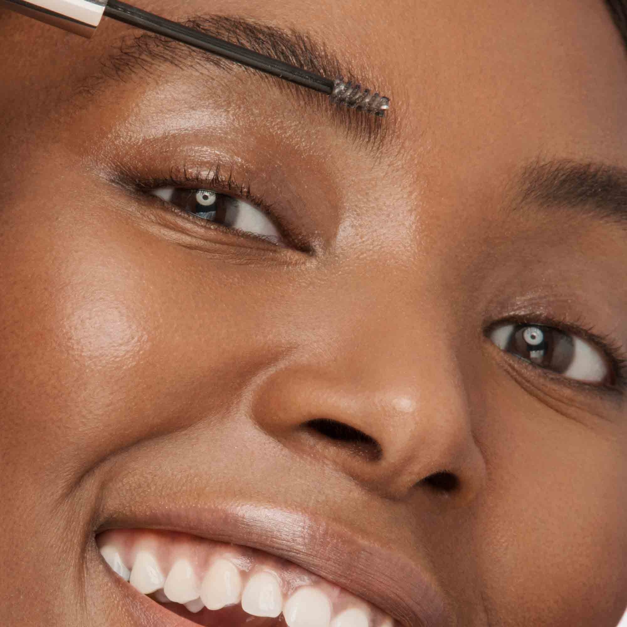 Woman applying Arch-ology Tinted Eyebrow Sculpting Gel on face