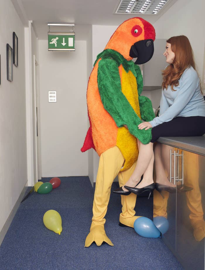person in a parrot costume flirting with a woman