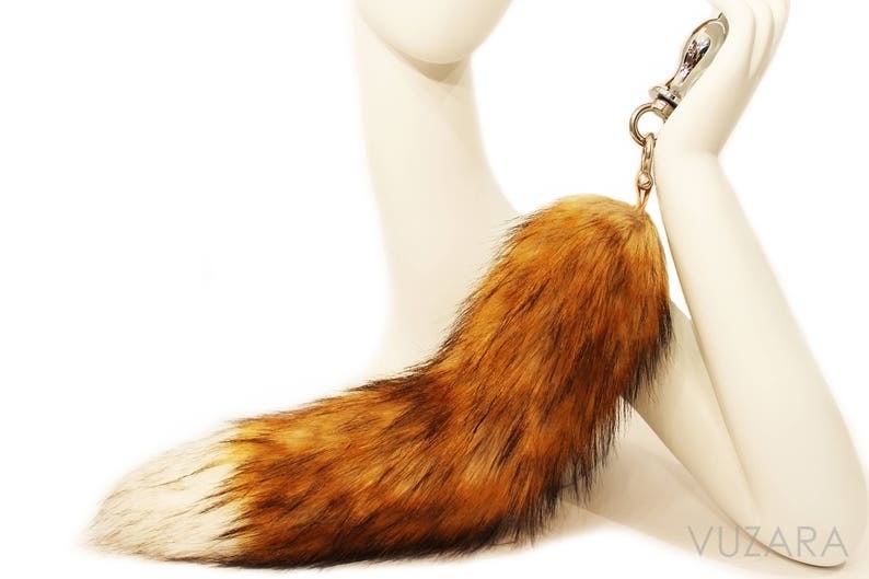 Mannequin holding faux fox tail metal butt plug