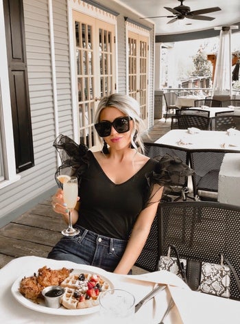 Reviewer wearing the black sleeveless bodysuit with sheer tulle puff shoulders