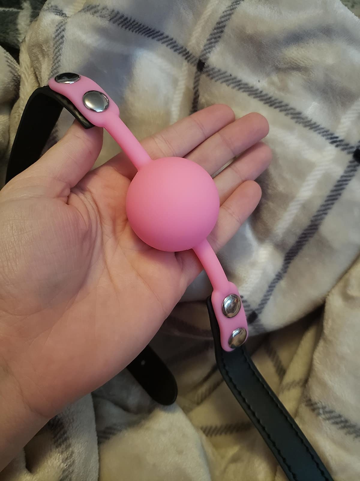 Reviewer holding pink ball gag