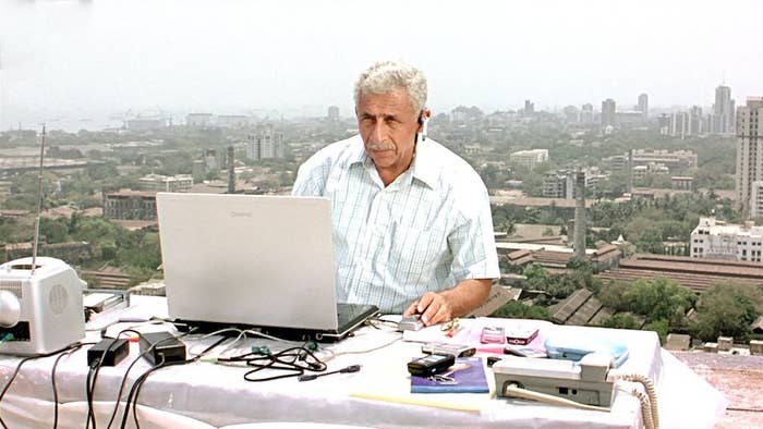 Naseeruddin Shah using a laptop while talking into an earpiece