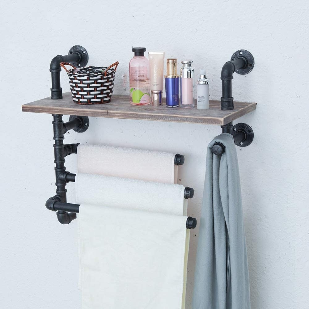 the industrial towel rack mounted on a wall with towels hanging from its bars