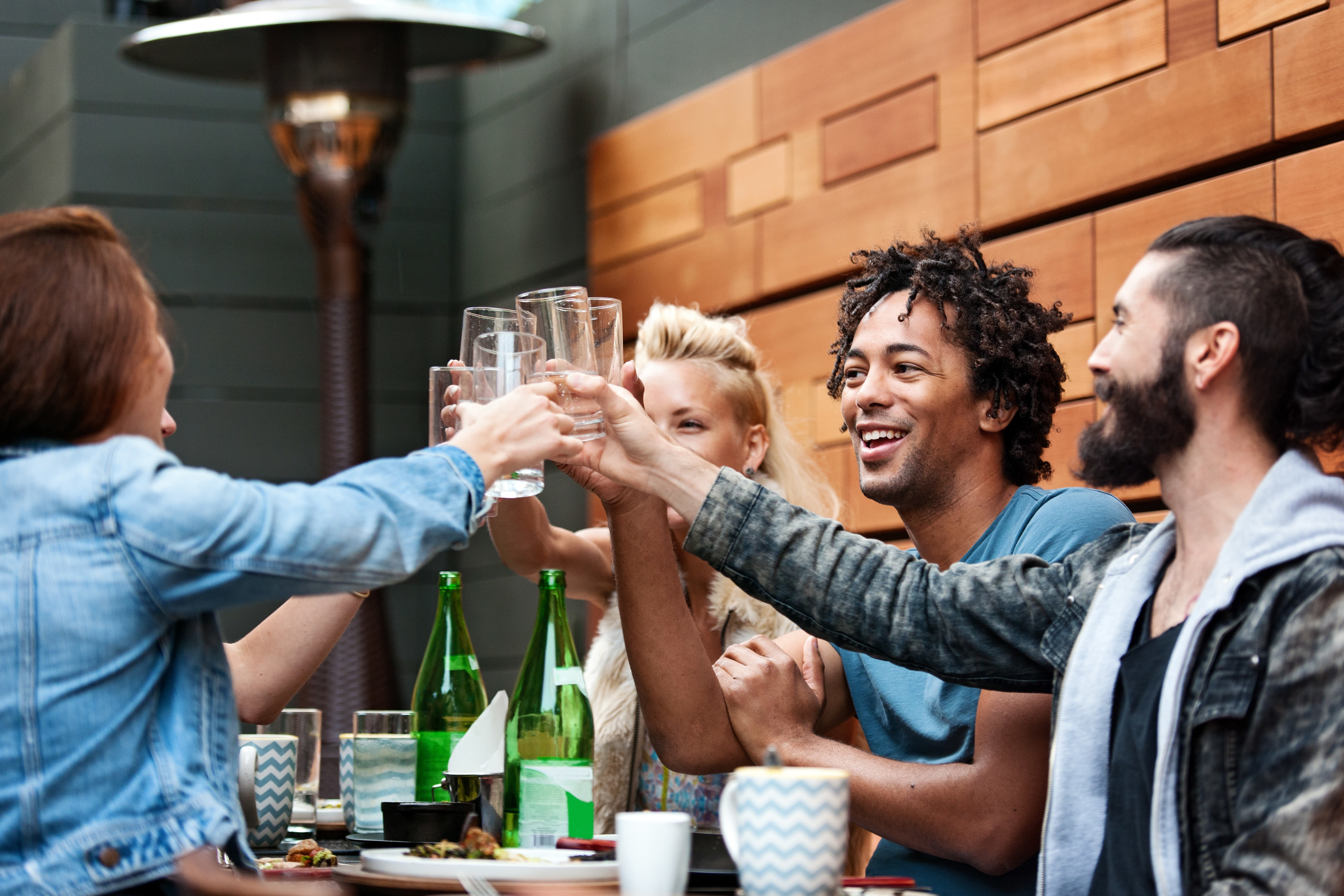 A group of friends cheers&#x27;ing their water glasses