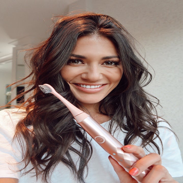 model holding the toothbrush in rose gold 