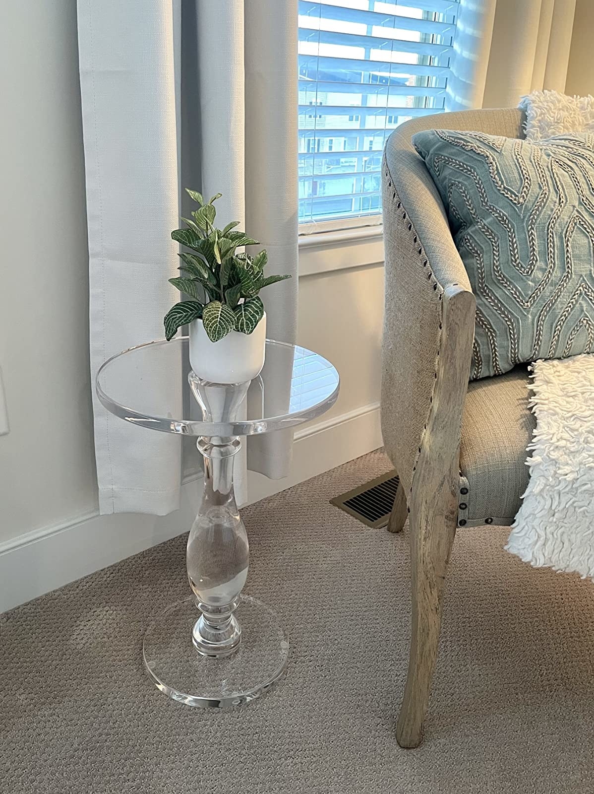 reviewer image of the clear acrylic side table next to an accent chair