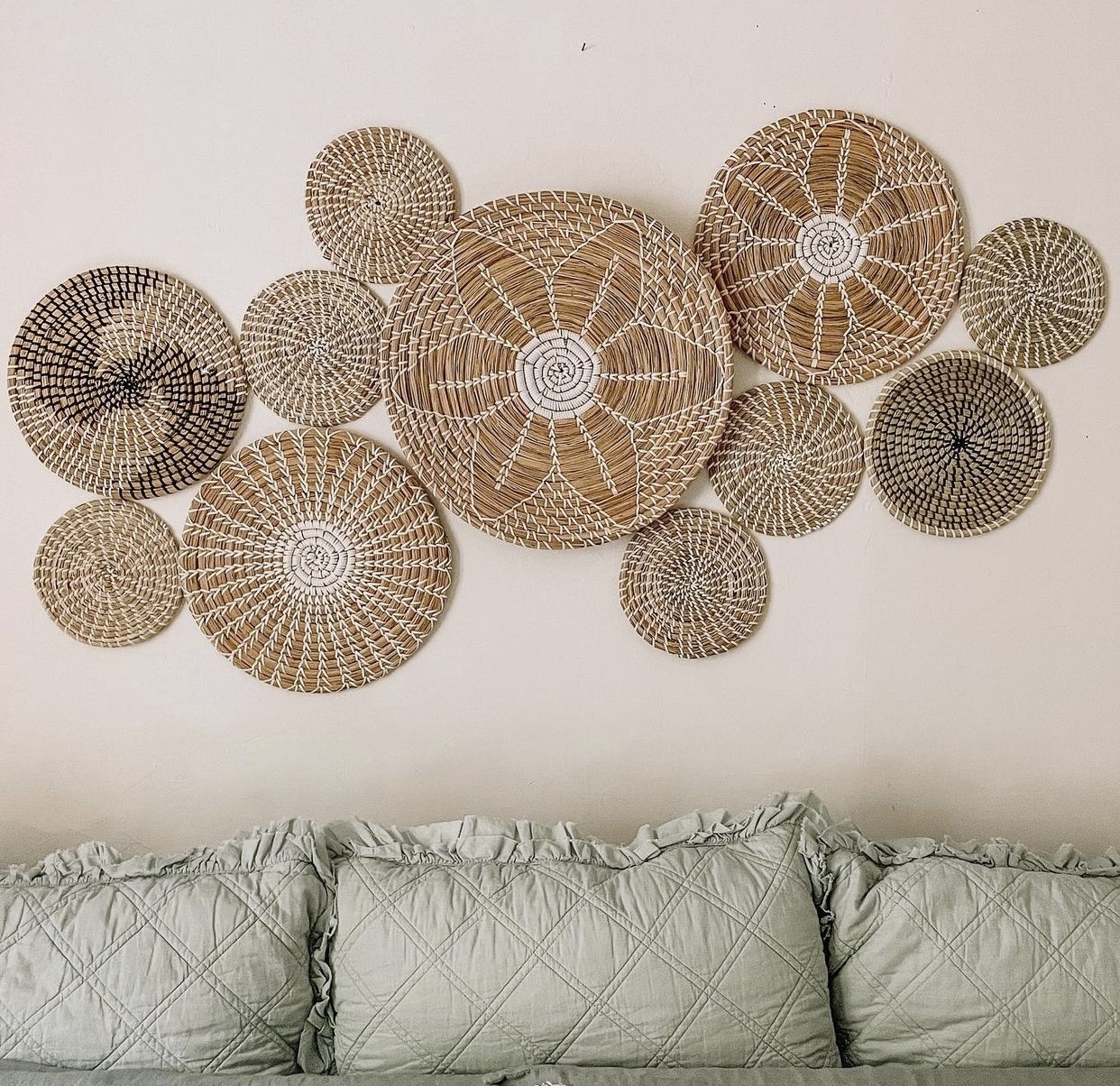 the set of handcrafted bowls, each of different sizes making a gallery wall above a bed