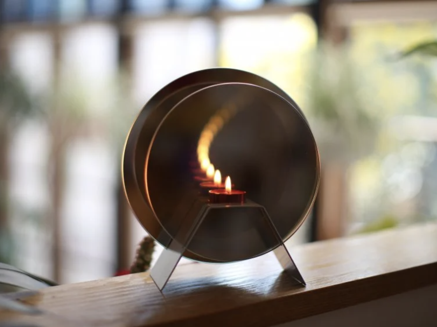circular candle holder with a mirror behind it that gives the illusion the candle goes on forever