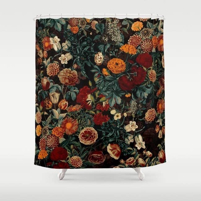 black shower curtain covered in dark marigolds and other flowers in orange, deep red, and cream colors