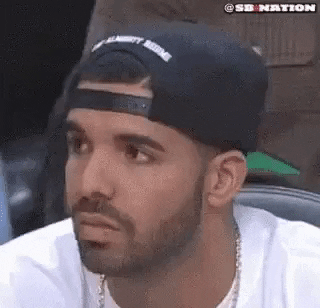 GIF of Drake, wearing a backward cap, slowly nodding and closing his eyes