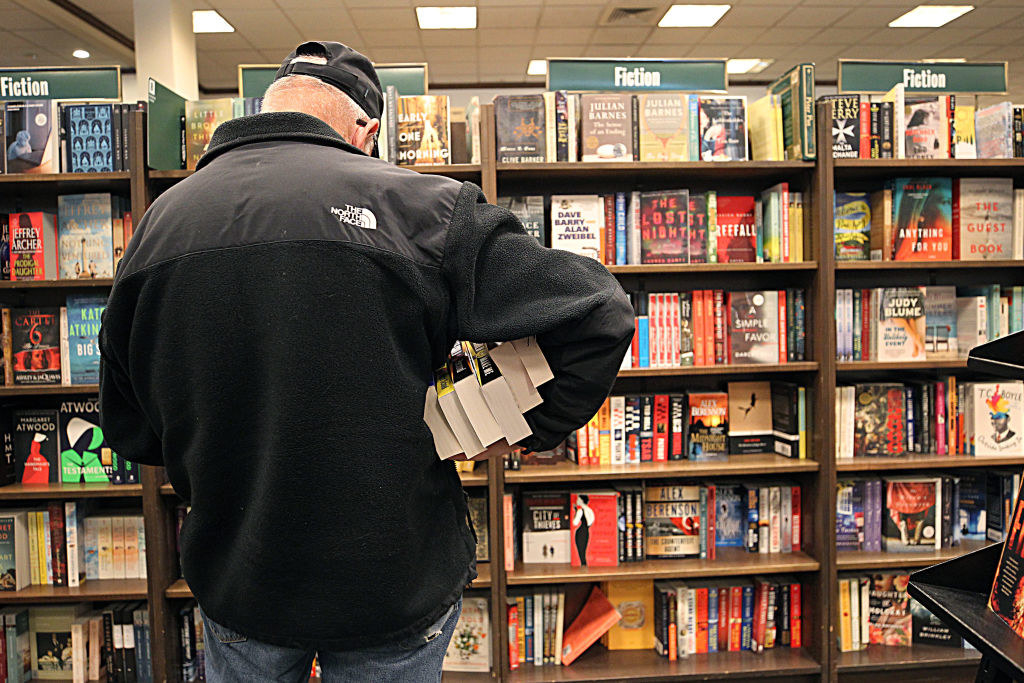 A customer purchases a stack of books from barnes and noble