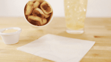 A bunch of pretzel bites fall out of a cup