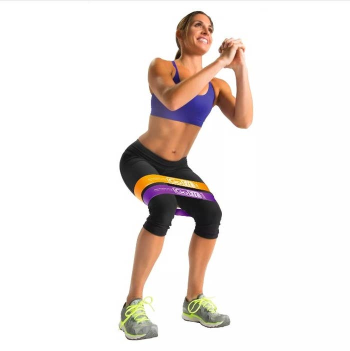 A model squatting with the three resistance bands on her mid thighs