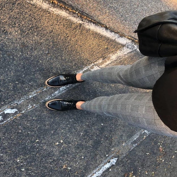 reviewer taking a photo from above and down towards legs showing the plaid gray print