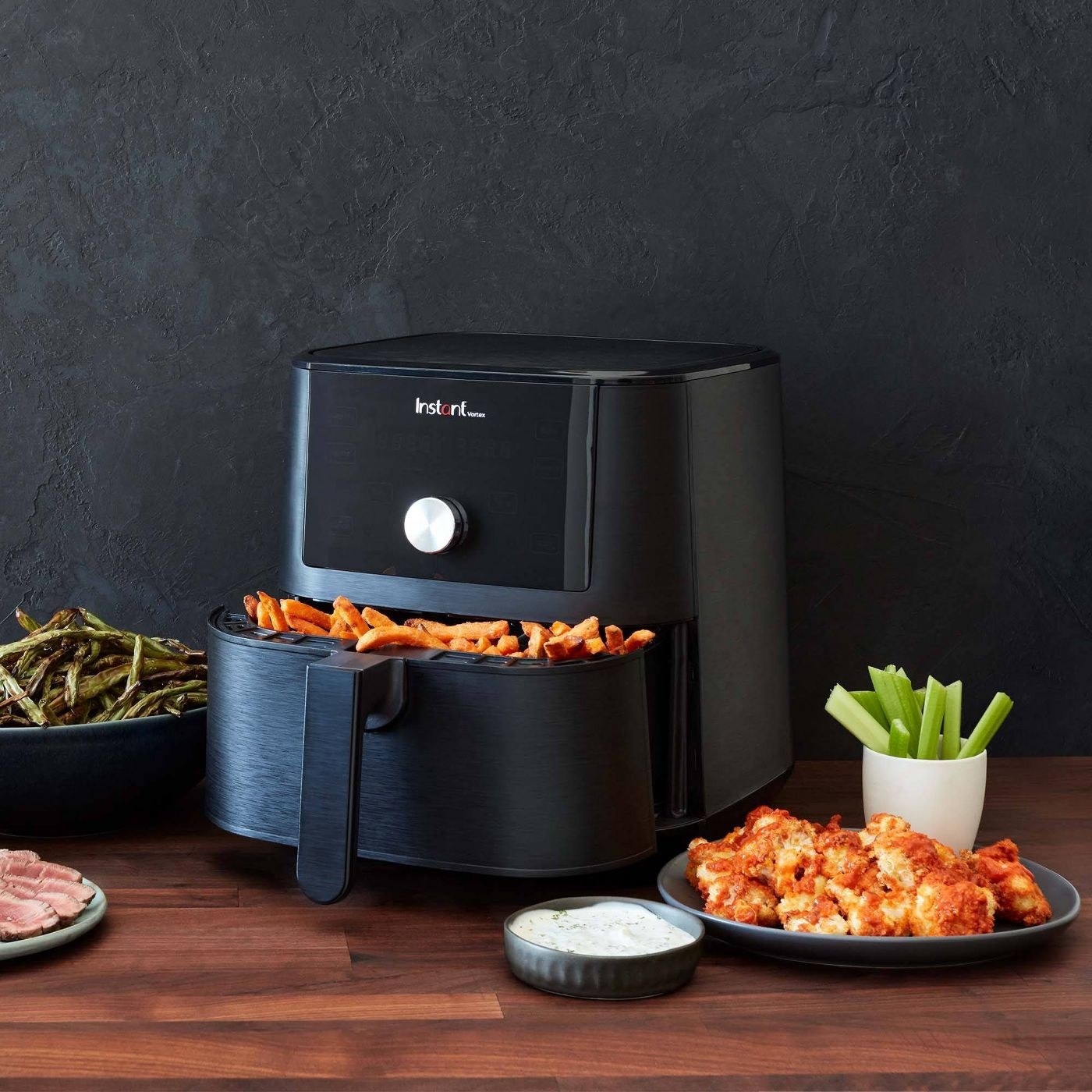 the air fryer with fries and wings and veggies