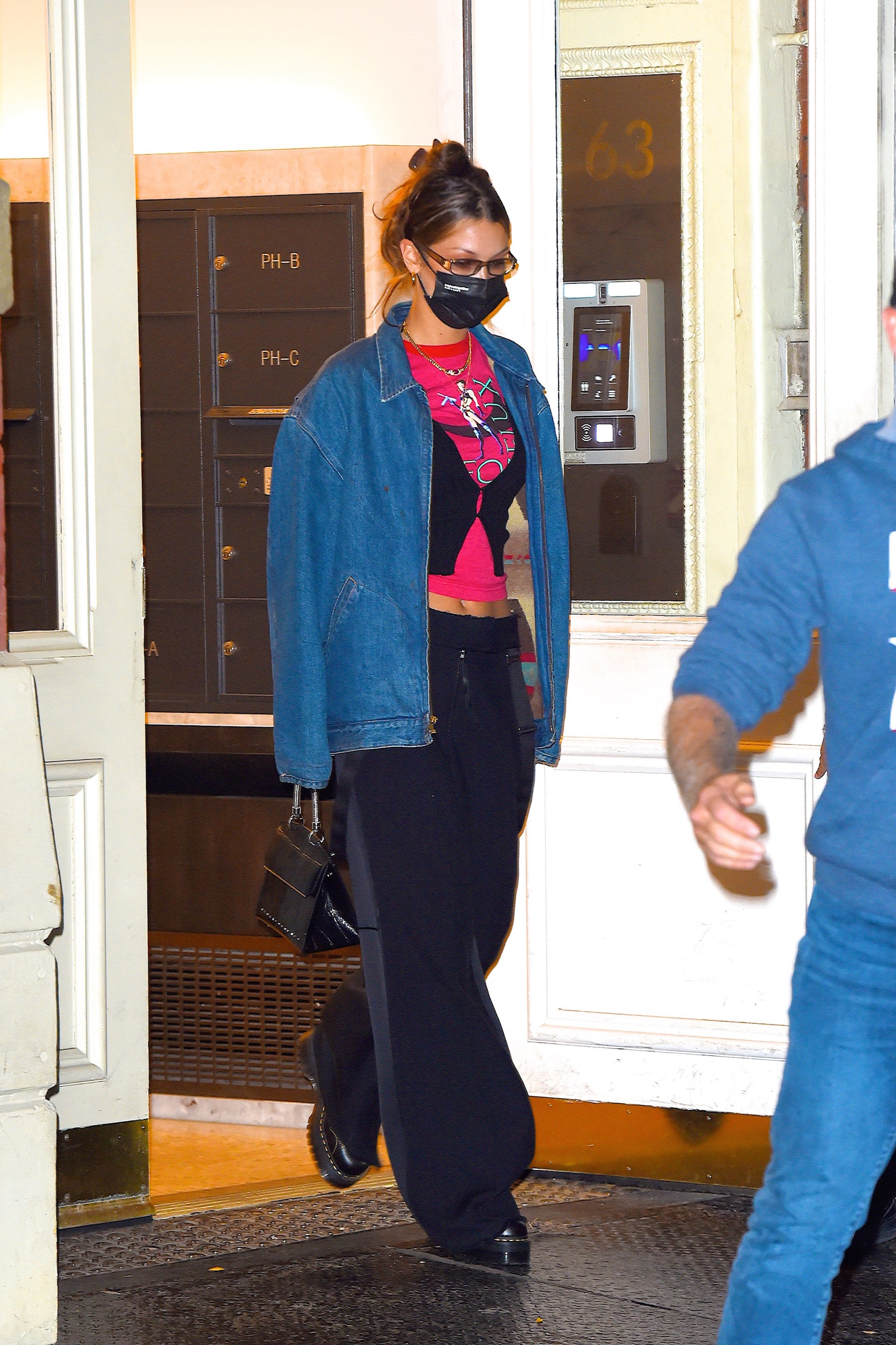 Bella Hadid in a jean jacket, vest and pink t-shirt