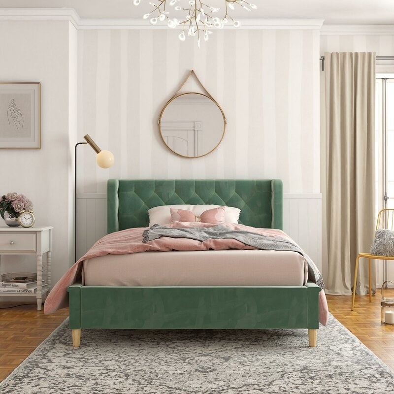 A bedroom housing the bed in emerald