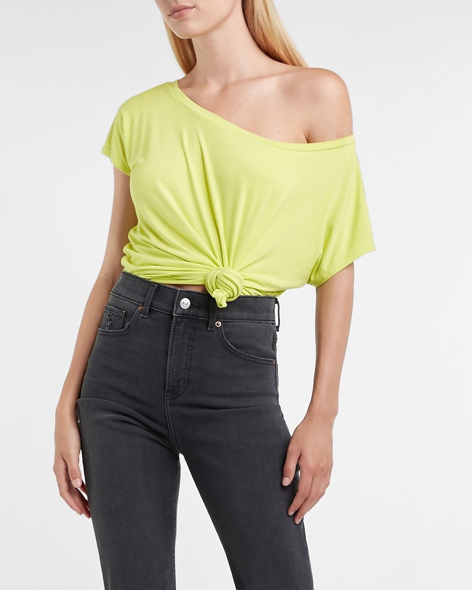 A model wearing a yellow off the shoulder tee