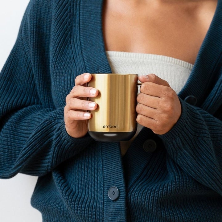 a model holding the smart mug in gold