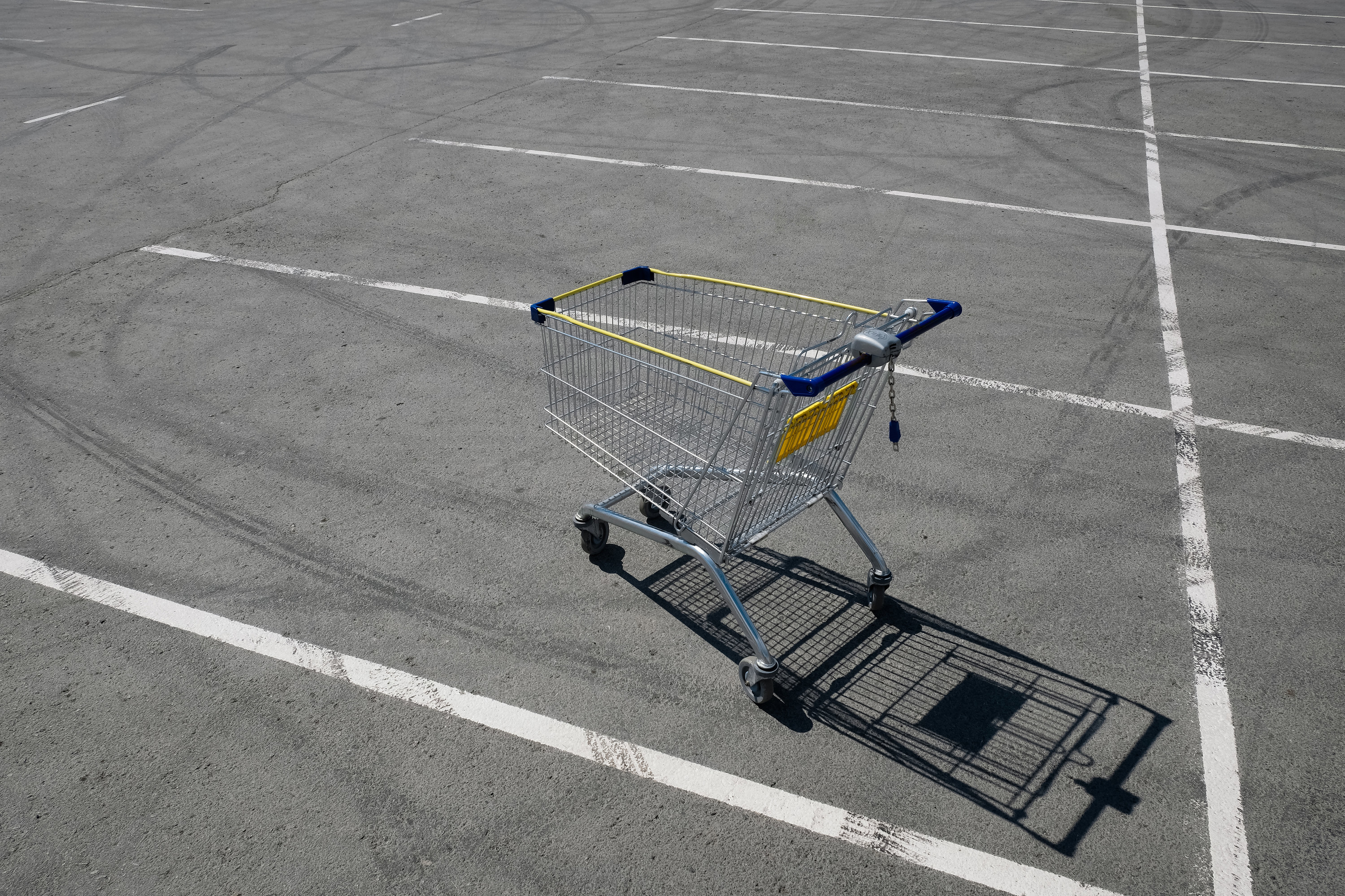 A shopping cart in the middle of a parking lot