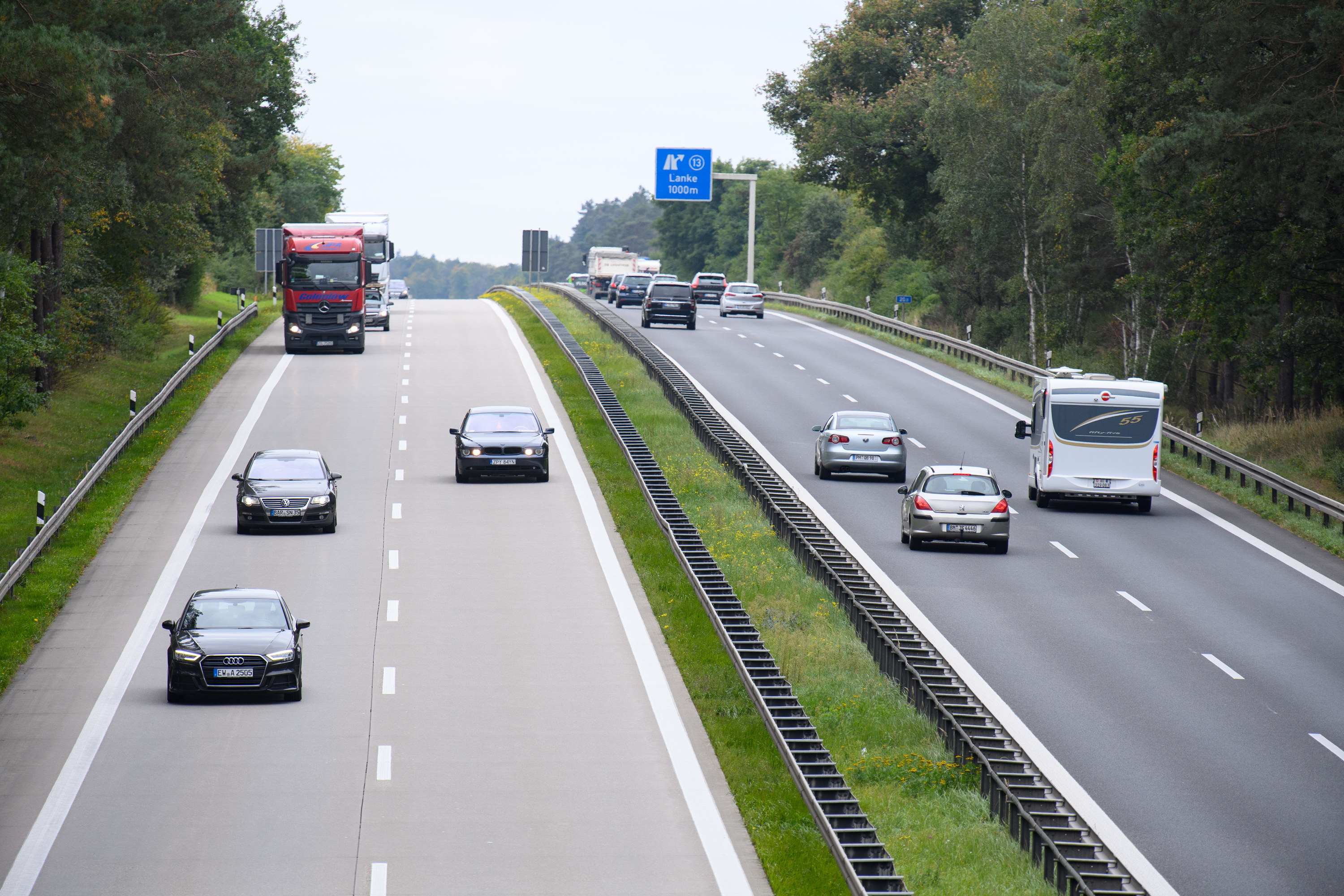 A four lane highway with cars traveling in opposite directions