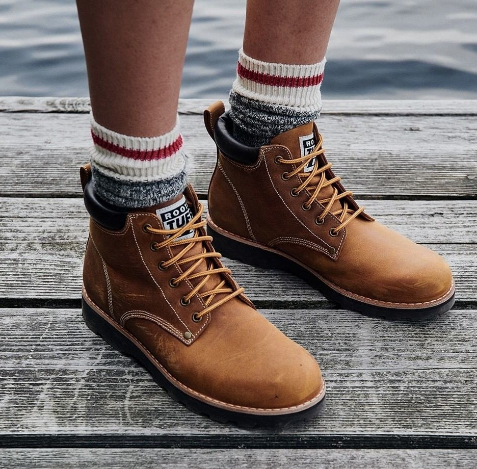 A person wearing the socks with boots on a dock