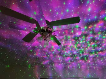 reviewer image of projector projecting fuchsia and green stars on walls and ceiling