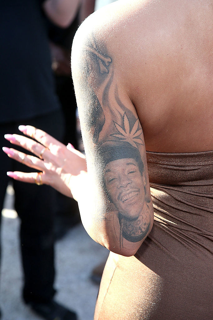 A portrait of a smiling Wiz Khalifa on the back of Amber Rose&#x27;s arm