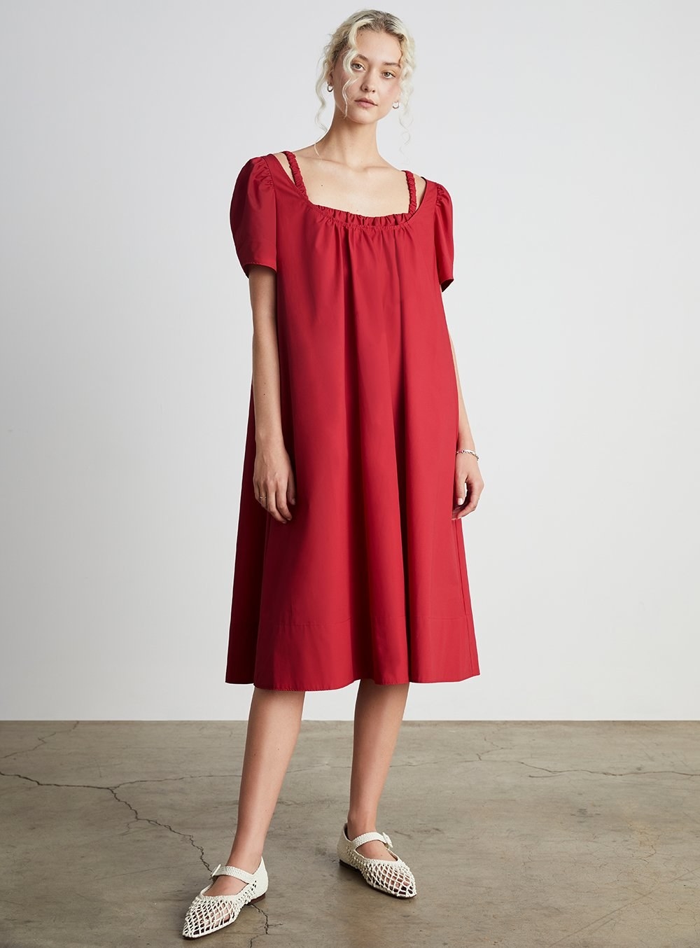 model wearing red smocked dress