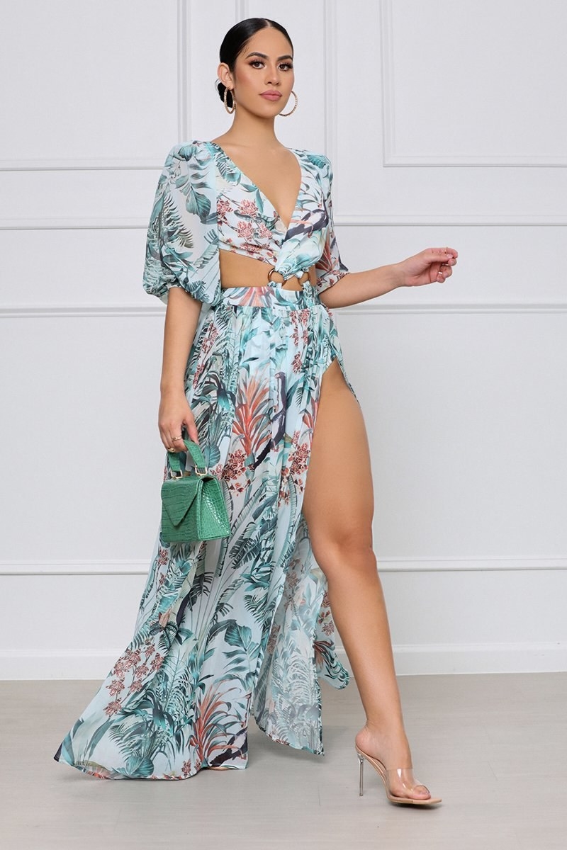 model wearing tropical print flowy maxi with high slits and cutouts near the waist