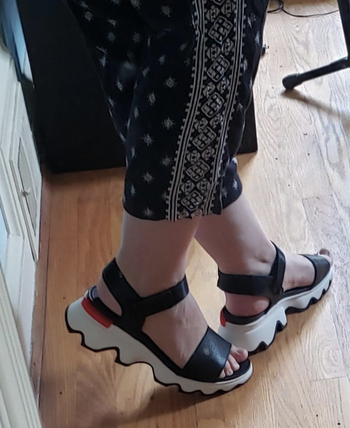 Reviewer photo of a closeup of white soled black strappy sandals 