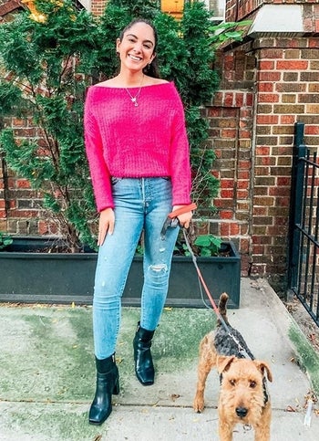 Reviewer wearing boots with jeans and a sweater