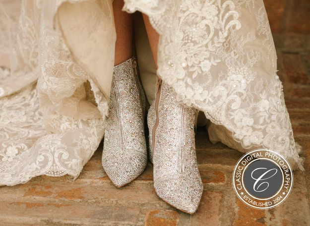 Reviewer photo of the boots covered in rhinestones peeking from underneath their wedding dress