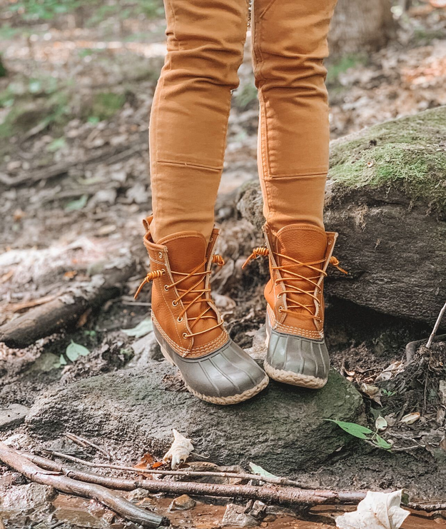 Writer is wearing the tan duck boots while standing on a small rock