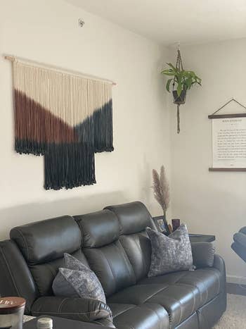macrame tapestry with brown and blue dyed sections hanging above a couch