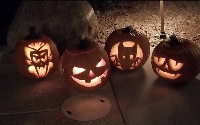 four jack-o&#x27;-lanterns with varying patterns carved from a book of templates