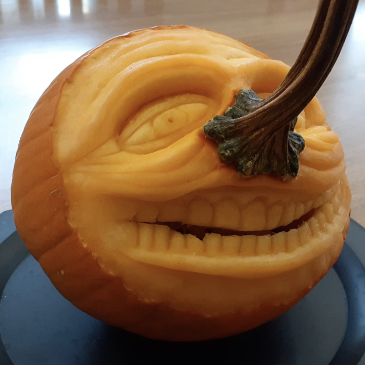 reviewer's pumpkin with realistic face with teeth and wrinkles carved in it