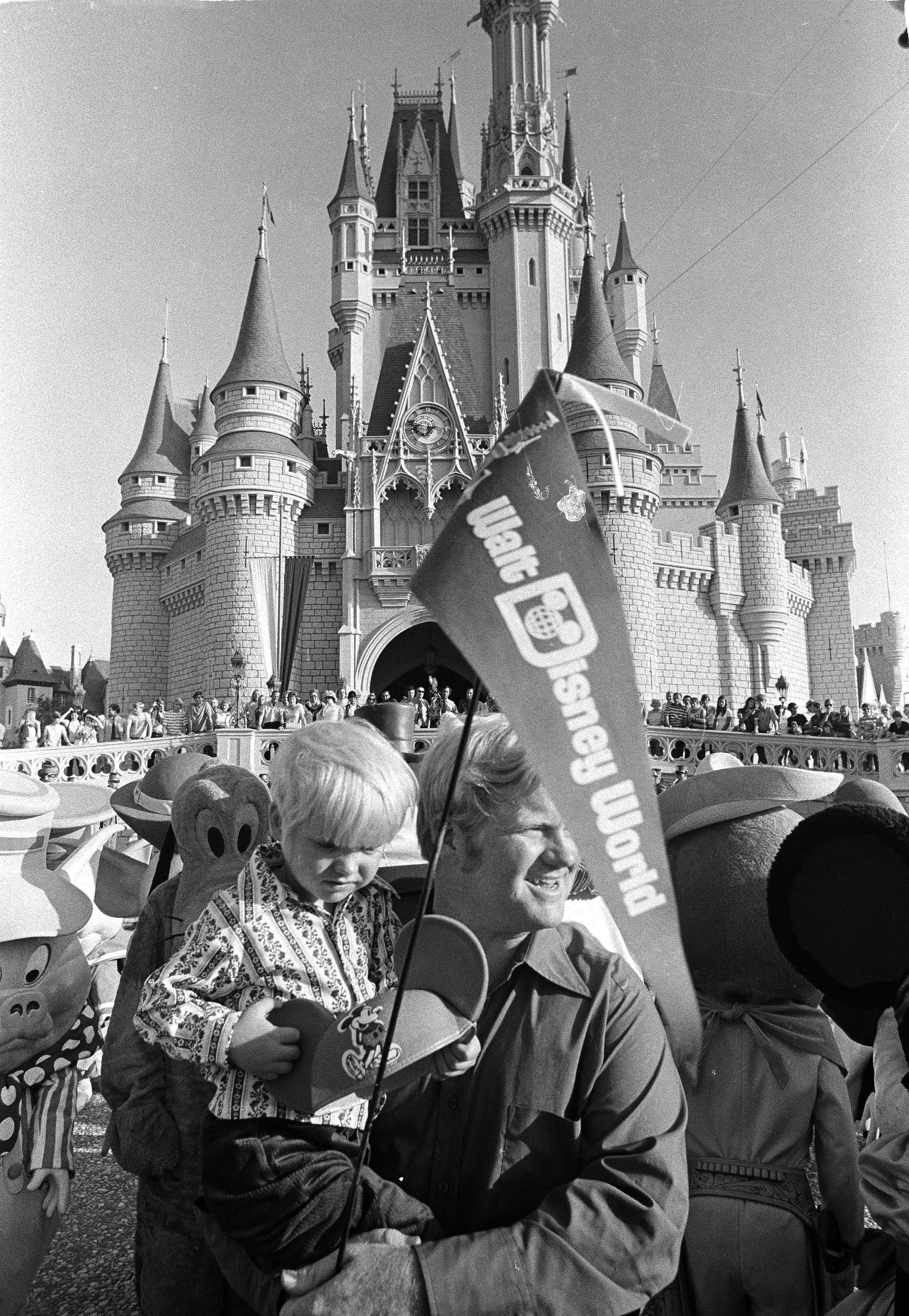 A young father holds his son outside the castle at Walt Disney Resort