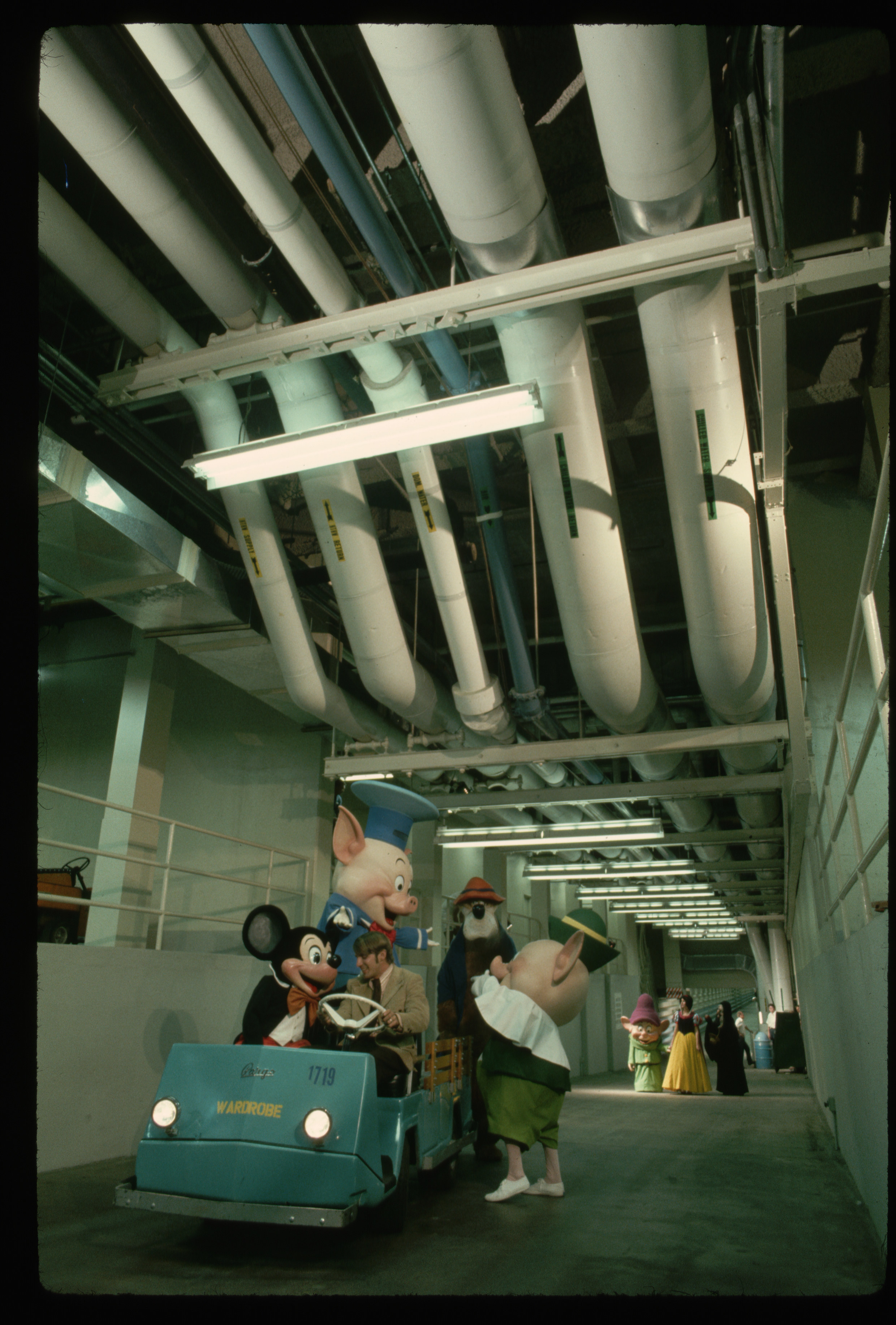 A candid view of Disney characters behind the scenes getting into a shuttle at Disney World