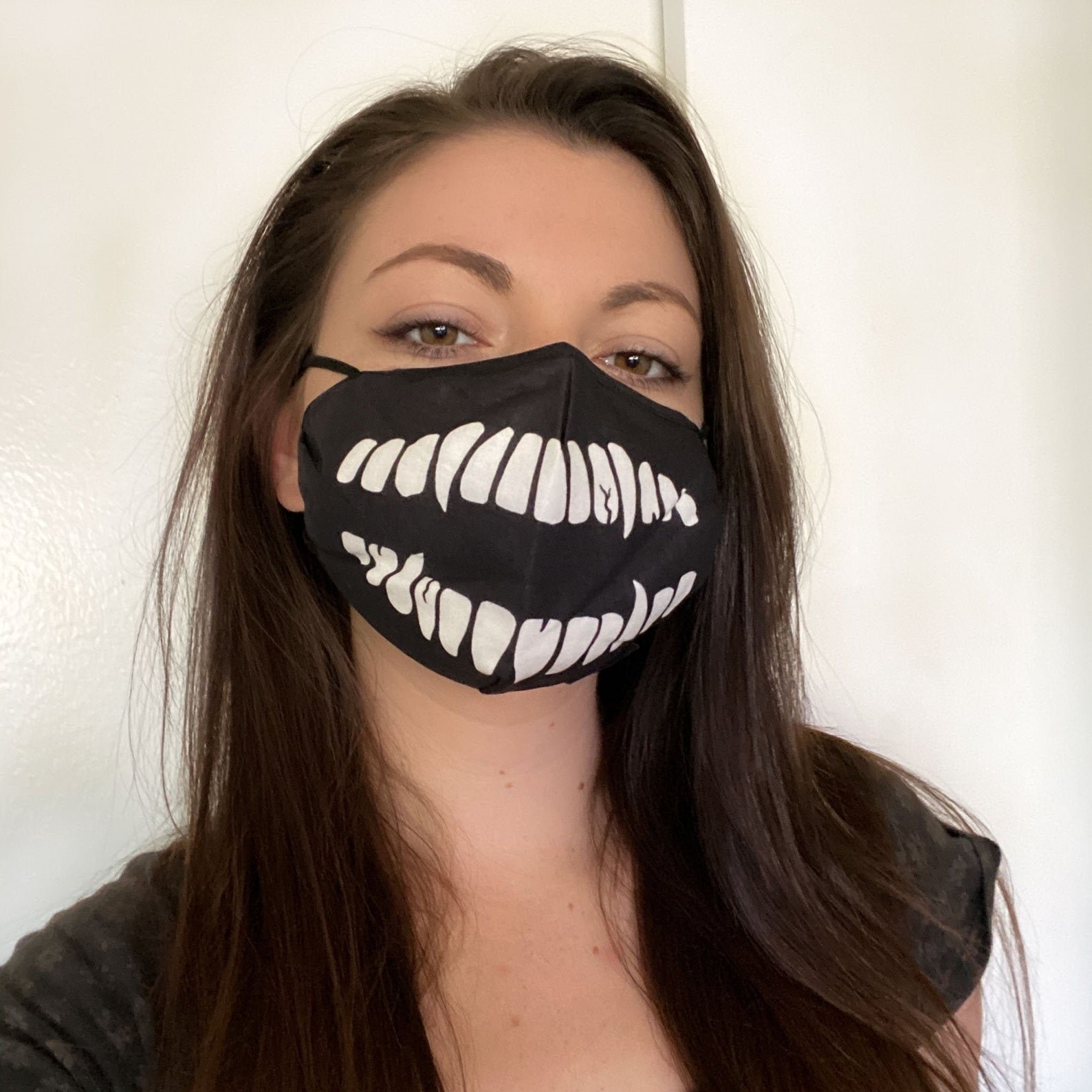 model wearing the black mask with white teeth on it