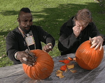 Mr. T and Conan O&#x27;Brien carving pumpkins at a picnic table