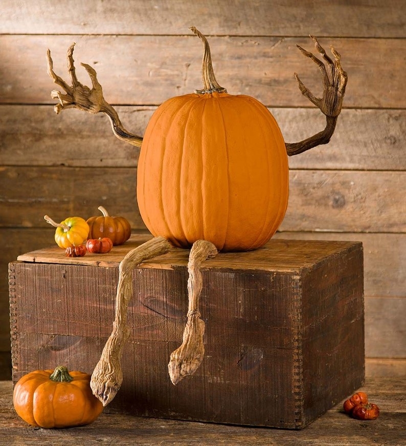 pumpkin with realistic looking stem arms and legs poking out of it