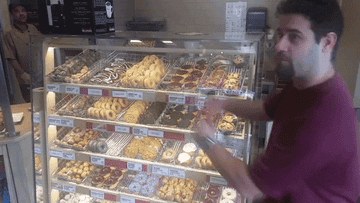 A GIF of a man showing off a donut display
